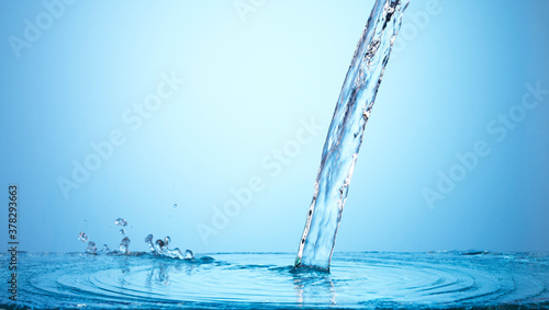 Pouring water on blue background