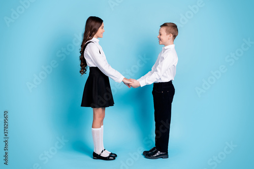 Fototapeta Full length profile photo of two girl boy schoolchildren shiny smiling hold hand