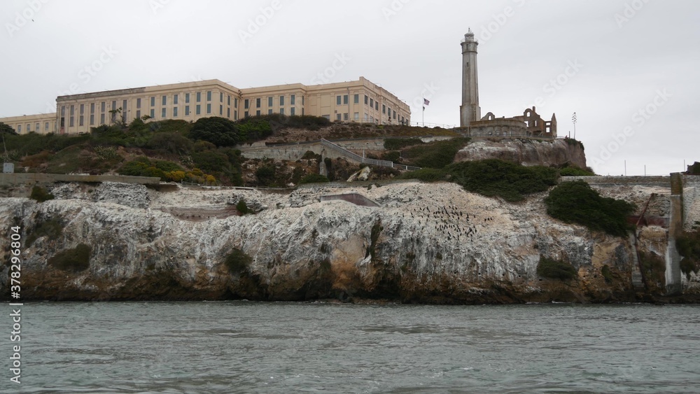Alcatraz island in San Francisco Bay, California USA. Federal prison for gangsters on rock, foggy weather. Historic jail, cliff in misty cloudy harbor. Gaol for punishment and imprisonment for crime