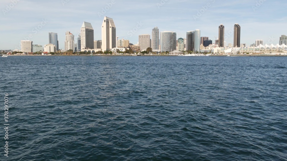Metropolis urban skyline, highrise skyscrapers of city downtown, San Diego Bay, California USA. Waterfront buildings near pacific ocean harbour. View from boat, nautical public transport to Coronado
