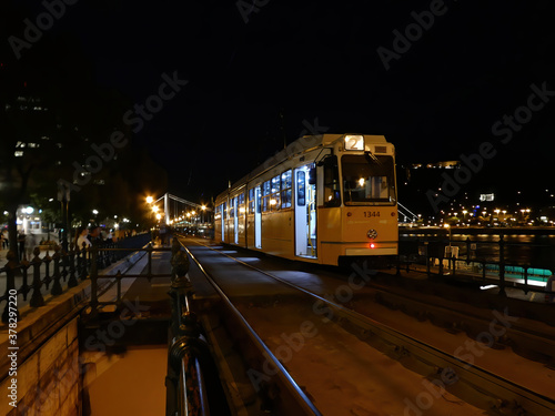 Yellow tramway number 2 passing by at night in Budapest, Hungar