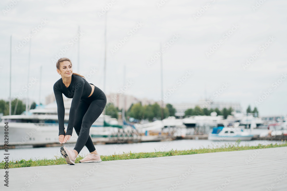does forward leaning exercises aerobics healthy lifestyle. stylish tight comfortable clothing. portrait of a beautiful athletic brunette woman of Caucasian appearance.
