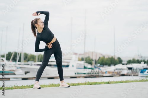 exercise aerobics healthy lifestyle. stylish tight comfortable clothing. nice weather summer day. portrait of a beautiful athletic brunette woman of Caucasian appearance. photo