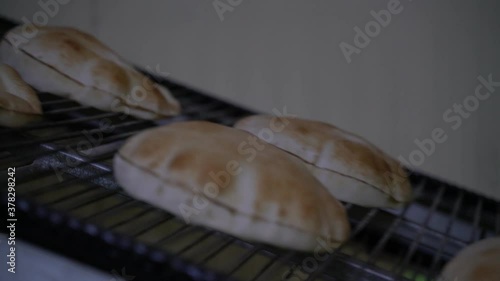 Fresh Arabic bread coming out of the oven photo