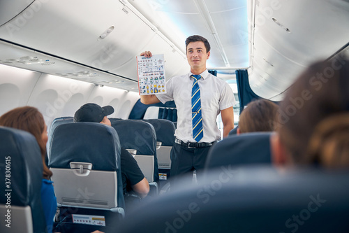 Handsome man holding safety information list to flight take off photo