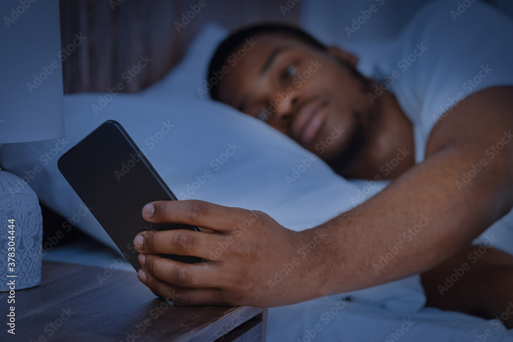 Guy Reading Message On Phone Lying In Bed At Night Guy Reading Message On Phone Lying In Bed At Night