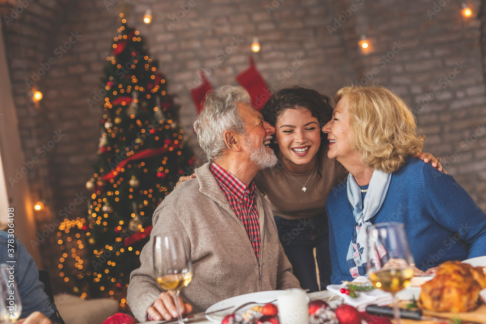 Parents kissing their daughter during Christmas dinner Parents kissing their daughter during Christmas dinner