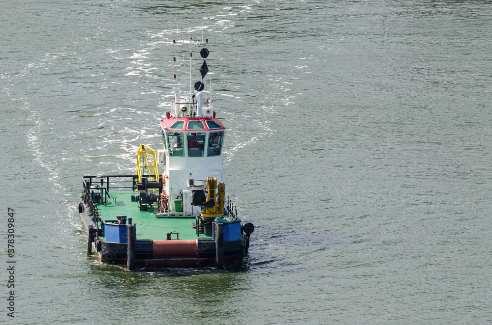 TUGBOAT - A small auxiliary ship is maneuvering at sea TUGBOAT - A small auxiliary ship is maneuvering at sea