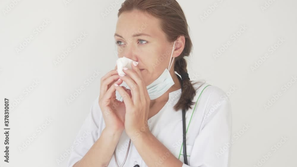 Beautiful woman doctor removes medical mask and is marked in a handkerchief Beautiful woman doctor removes medical mask and is marked in a handkerchief