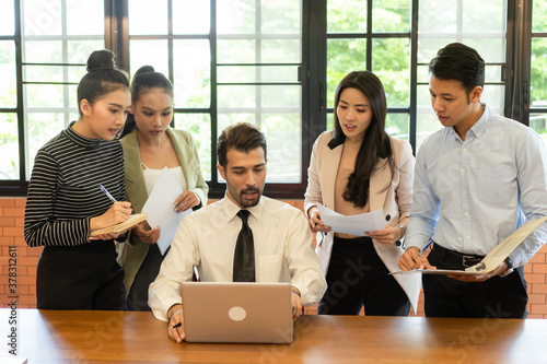 Asian teamwork business people  working in modern office .Group of man and woman focus to the manager's job description through the computer.