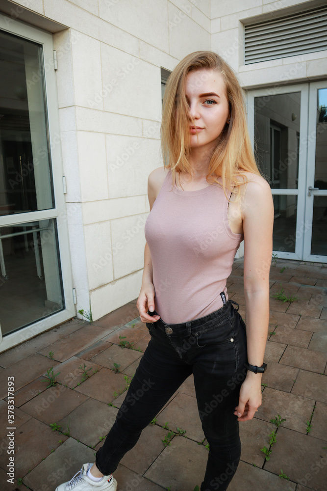 Portrait shooting of a stylish girl. Beige shades. Trends of spring and summer 2020.Black pants and beige body suit Portrait shooting of a stylish girl. Beige shades. Trends of spring and summer 2020.Black pants and beige body suit