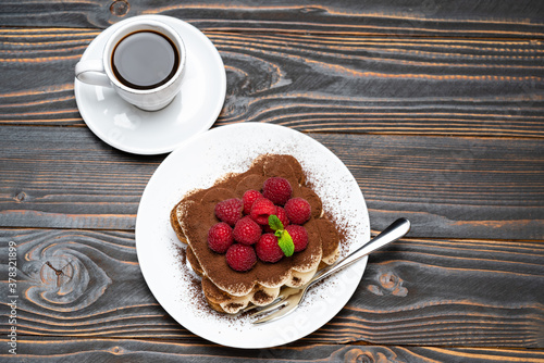 Wallpaper Mural portion of Classic tiramisu dessert with raspberries and cup of espresso coffee isolated on wooden background Torontodigital.ca