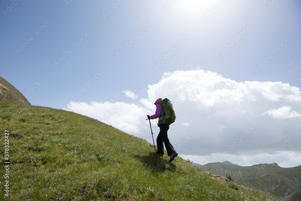 Successful woman hiker climbing to high altitude mountian top