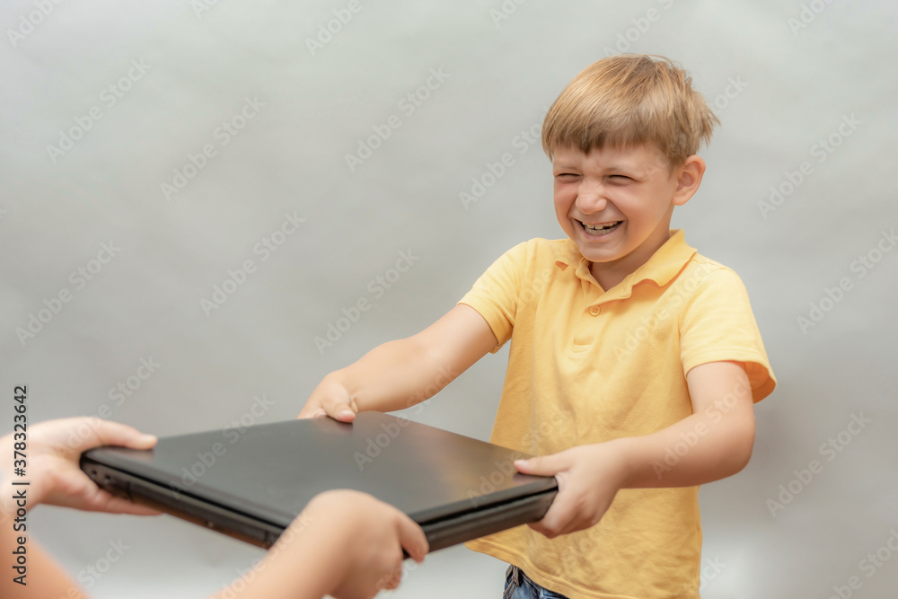 A naughty boy, addicted to computer games, snatches a laptop out of his parents' hands. A naughty boy, addicted to computer games, snatches a laptop out of his parents' hands.