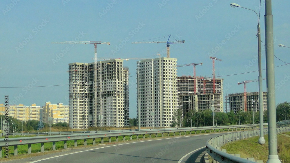 New multi storey residential buildings in Odintsovo district of Moscow region, view from empty road at Sunny summer day on blue sky background