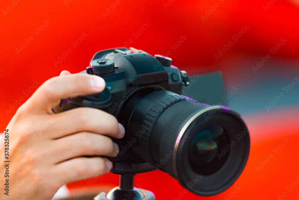Close up photo of man shooting video with camera outdoor