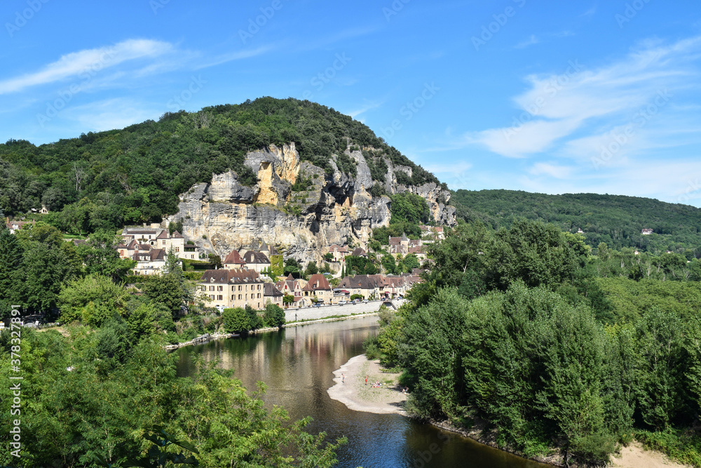 Village of houses on the mountainside and a river surrounded by nature. La Roque-Gageac, France
