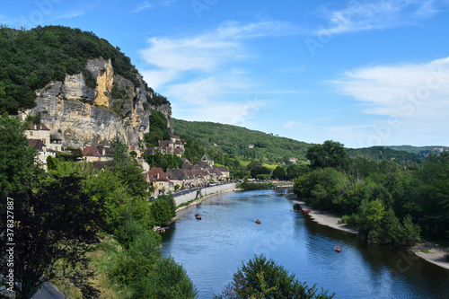 Village of houses on the mountainside and a river surrounded by nature. La Roque-Gageac, France 