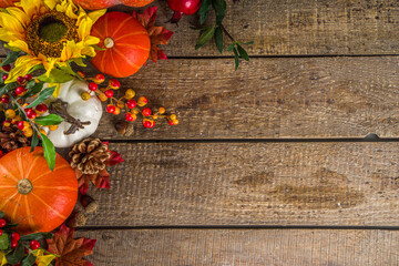 Festive autumn background, with traditional decor - pumpkins, berries, fruits, leaves on old wooden background. Thanksgiving day and Halloween holiday greeting card concept. Autumn flatlay