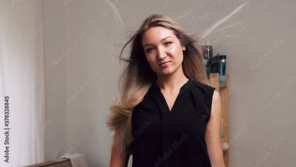 Young woman looks into the camera. Developing beautiful blonde long hair. Healthy hair. Young woman looks into the camera. Developing beautiful blonde long hair. Healthy hair.
