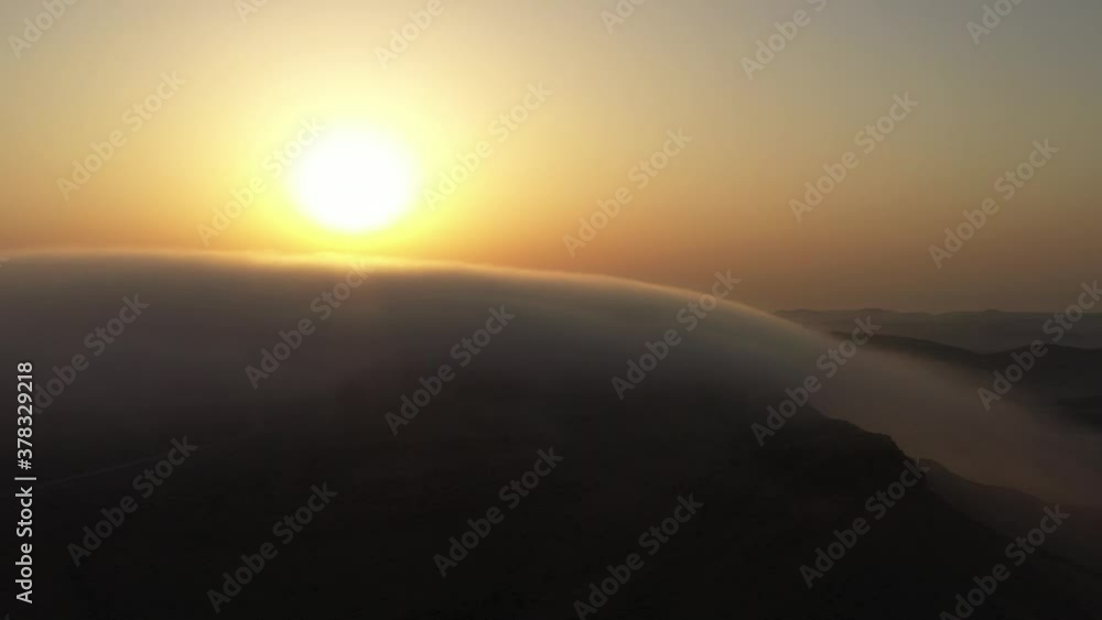 Nature amazing phenomenon of cloud surfing above mountains rock in desert. Magical moment above the clouds at sunrise. Shot from mountain peak highrise skyline. Dreaming mystical scene Nature amazing phenomenon of cloud surfing above mountains rock in desert. Magical moment above the clouds at sunrise. Shot from mountain peak highrise skyline. Dreaming mystical scene