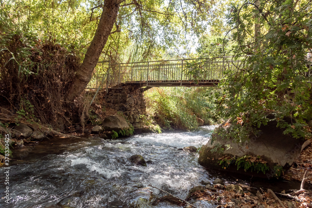 The bridge over the swift mountainous Hermon River with crystal clear waters in the Golan Heights in northern Israel The bridge over the swift mountainous Hermon River with crystal clear waters in the Golan Heights in northern Israel