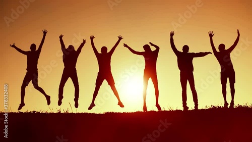 Cheerful friends jumping up at the sunset photo