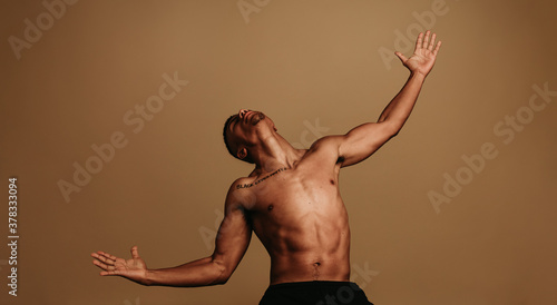 Portrait of muscular man with stretched arms