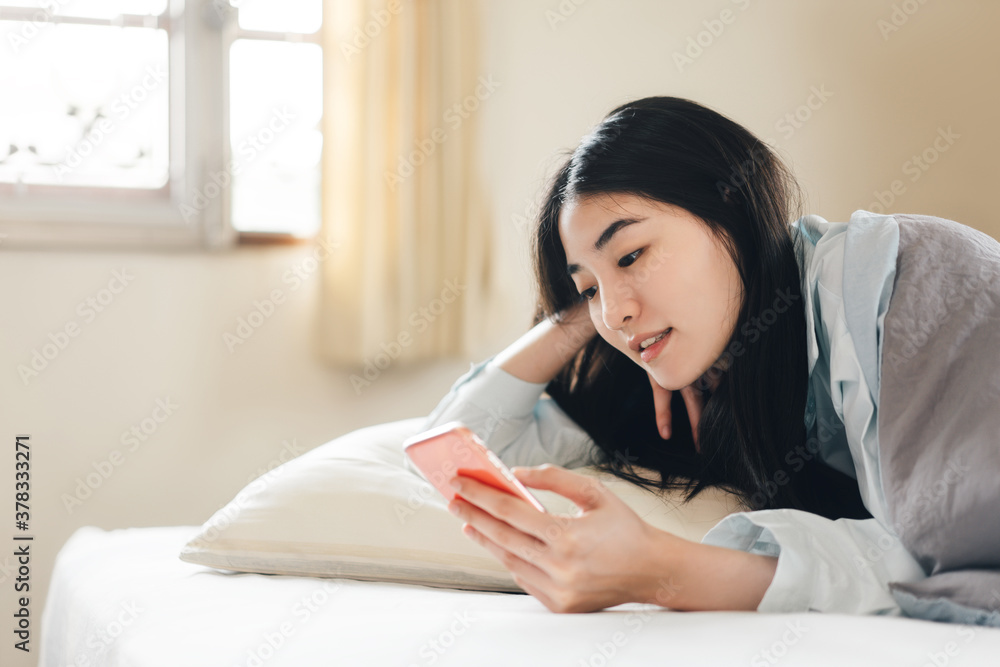 Young adult single woman using smartphone in the moring for social message app chat with friend Young adult single woman using smartphone in the moring for social message app chat with friend
