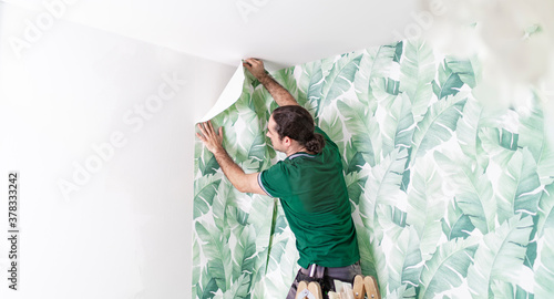 Malermeister tapeziert eine Wohnung mit einer schönen Tapete