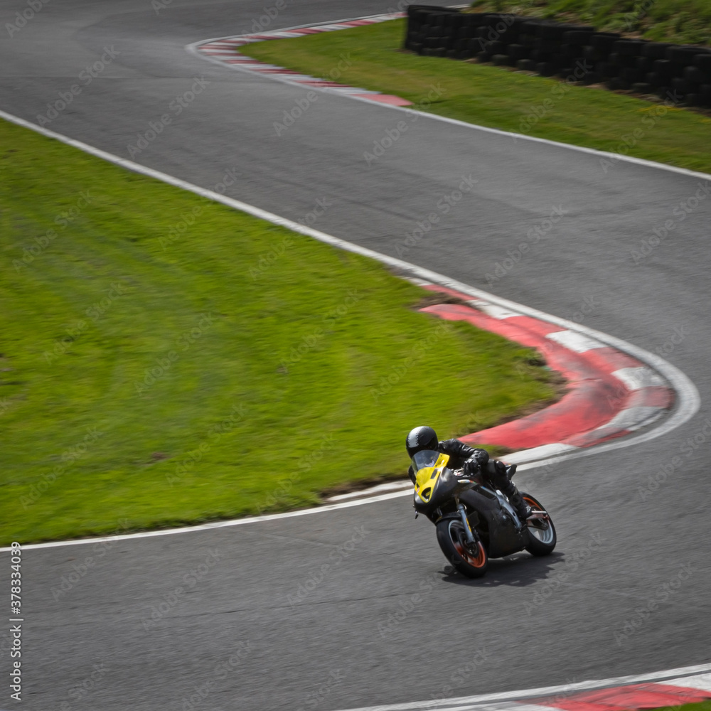 A panning shot of a racing bike as it circuits a track. A panning shot of a racing bike as it circuits a track.