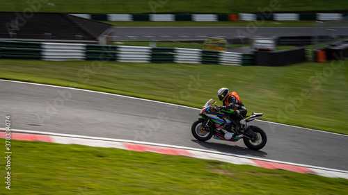 A panning shot of a racing bike as it circuits a track.