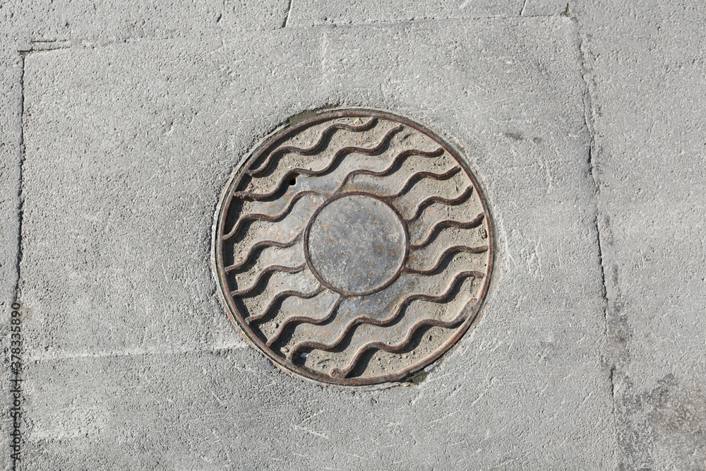Metal manhole on the sidewalk