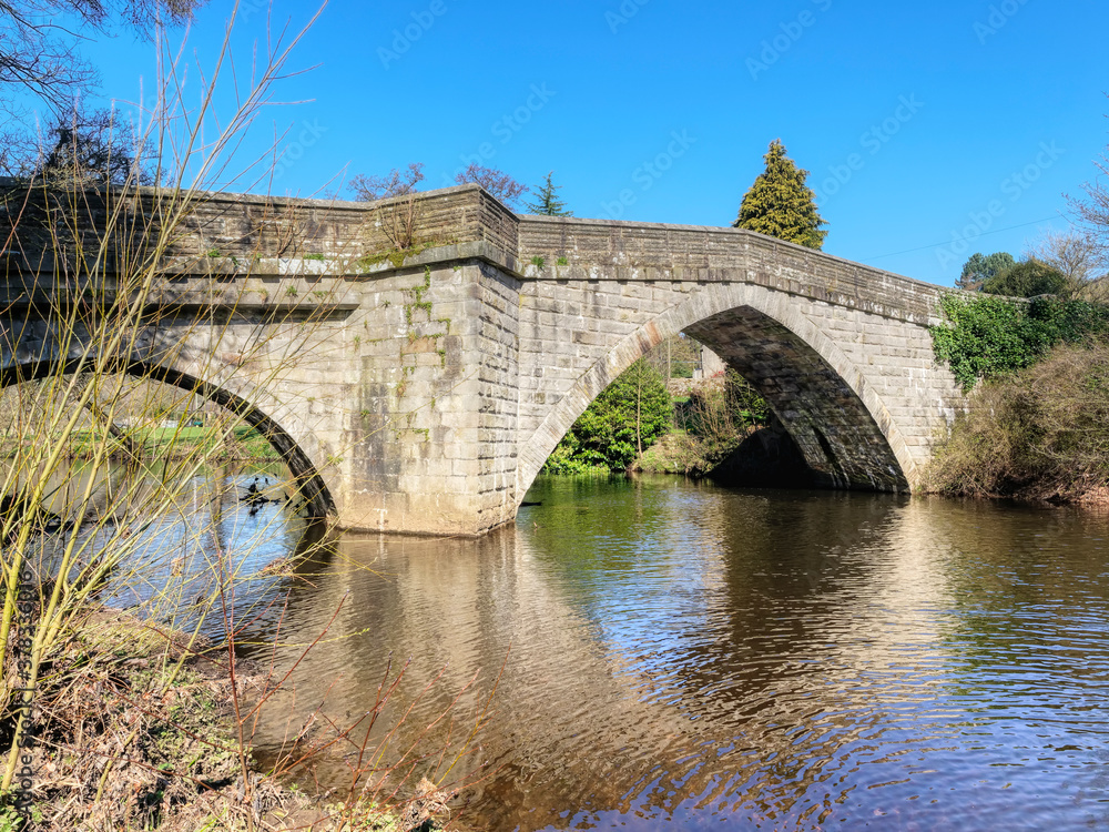 Stone built arched bridge over the River Derwent in the town of Froggat in Derbyshire