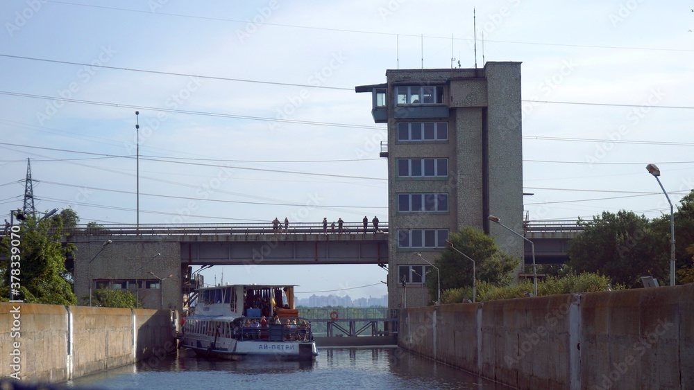 Obraz premium Vyshgorod, Kiev region, Ukraine - September 2020: A pleasure motor ship passes the locks of the Kiev reservoir. The motor ship passes the gateway of the Kiev sea.