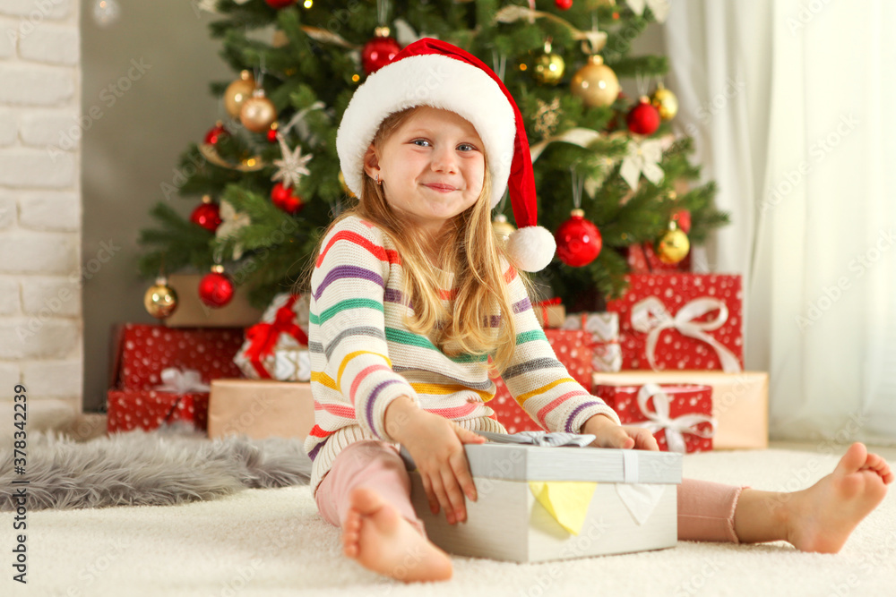 Little girl with christmas gifts in christmas interior
