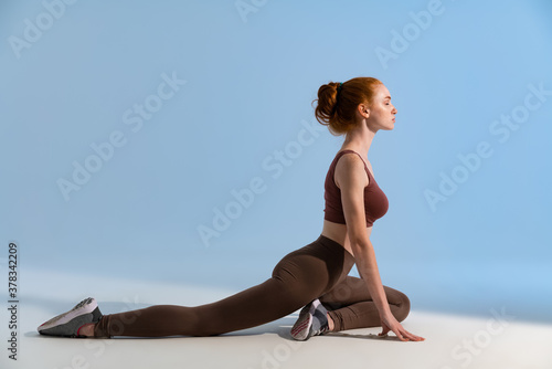 Fotografie Photo of young focused sportswoman doing exercise while working out