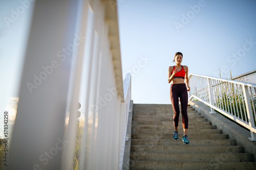 Beautiful fit female runner jogging during outdoor workout