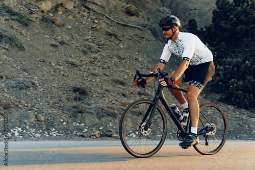 Professional cyclist on a mountain road at sunrise