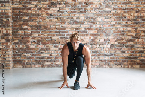 Photo of athletic young sportsman doing exercise while working out