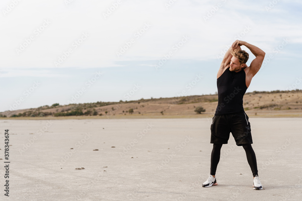 Photo of athletic young sportsman doing exercise while working out Photo of athletic young sportsman doing exercise while working out