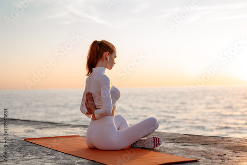 Canvas Print Image of redhead calm sportswoman doing yoga exercise on promenade