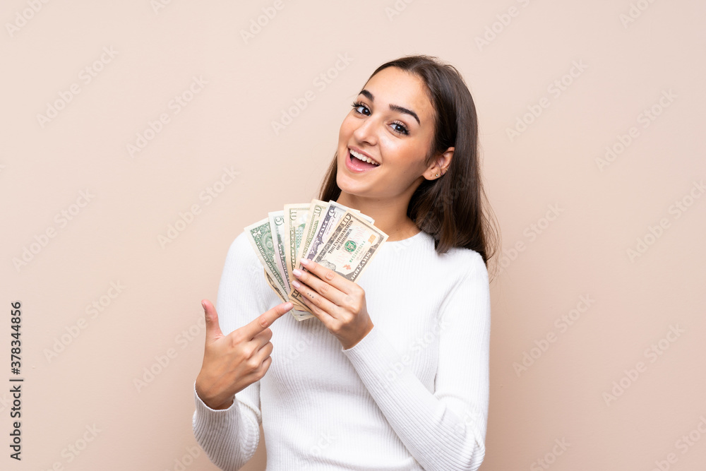 Young woman over isolated background taking a lot of money Young woman over isolated background taking a lot of money