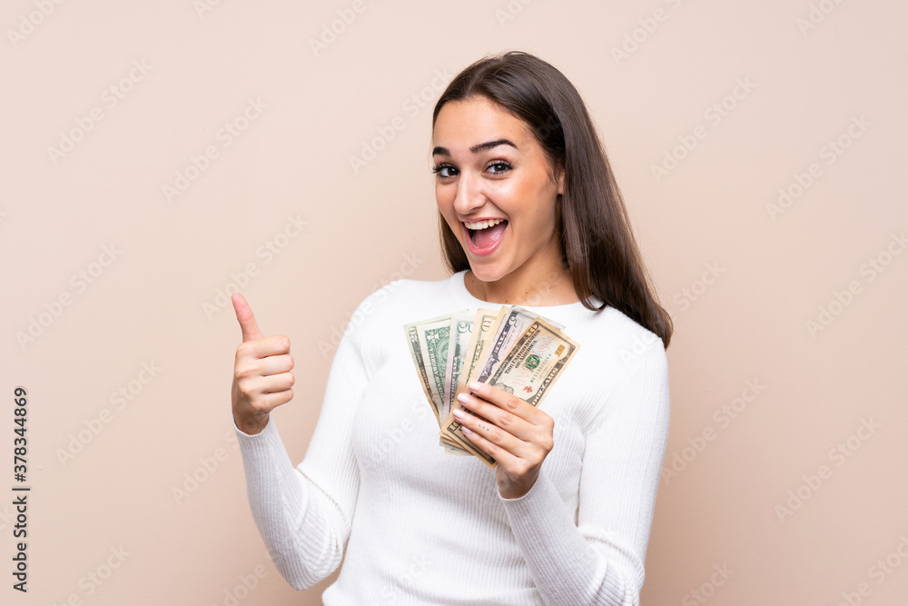 Young woman over isolated background taking a lot of money Young woman over isolated background taking a lot of money