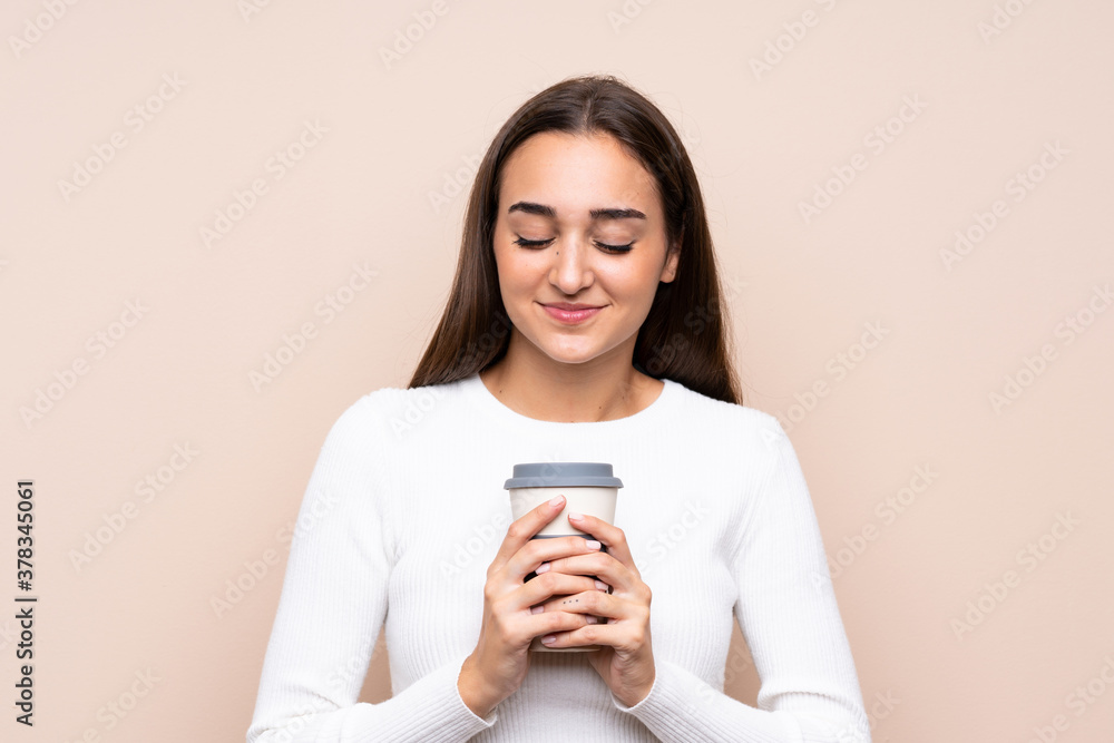 Young woman over isolated background holding coffee to take away Young woman over isolated background holding coffee to take away