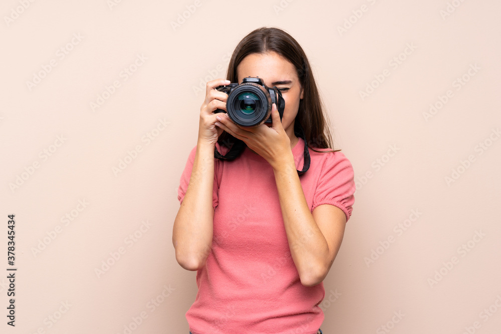 Young woman over isolated background with a professional camera