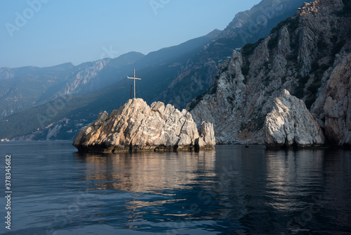 Mountain view of the island in the sea with a wooden cross near Mount Athos, Greece photo