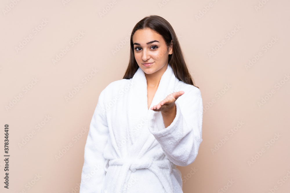 Young girl in a bathrobe over isolated background handshaking after good deal Young girl in a bathrobe over isolated background handshaking after good deal