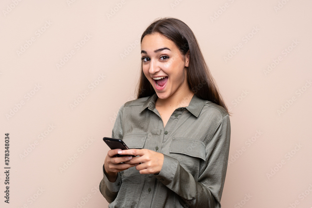 Young girl over isolated background surprised and sending a message Young girl over isolated background surprised and sending a message
