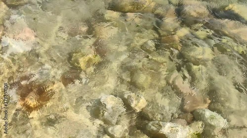 Beach with stones and pebbles under the waves 